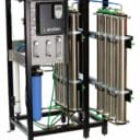Industrial water filtration system with stainless steel canisters, gauges, and a digital control panel.