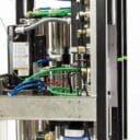 Complex water filtration system featuring stainless steel components, colorful tubing, and various valves and gauges.
